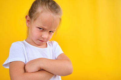 Cute angry unsatisfied pre school girl arms crossed expressing disagreement