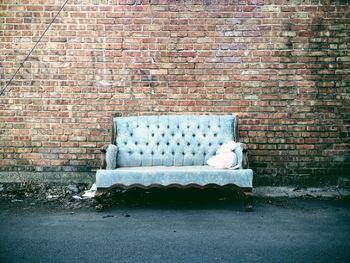 Couch against brick wall on street