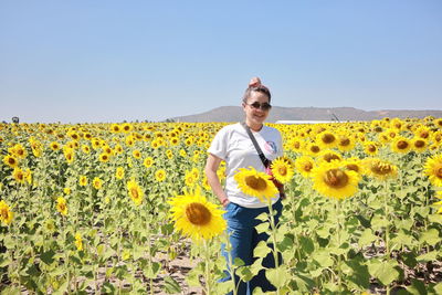 Woman standing in sunflower field