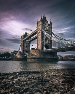 Tower bridge over thames river against sky during sunset