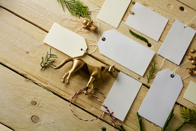 High angle view of blank labels with figurines arranged on wooden table