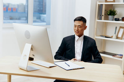 Portrait of businessman using laptop at office