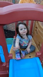 Portrait of cute girl sitting outdoors