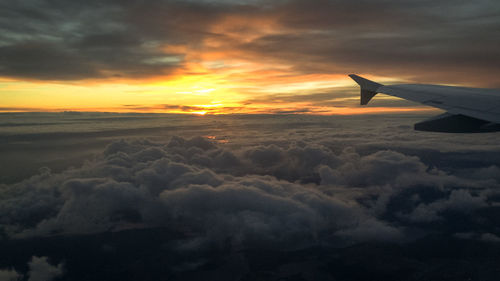 Cropped image of airplane flying over clouds