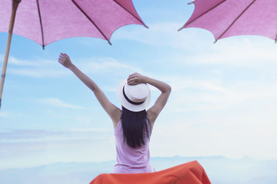 Rear view of woman standing against sky