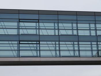 Low angle view of glass building against sky