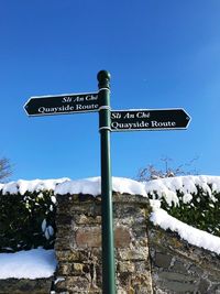 Low angle view of signboard against clear sky