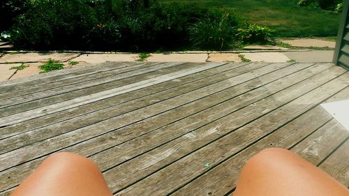 Low section of person relaxing on wooden floor