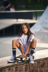 Portrait of young woman sitting on street