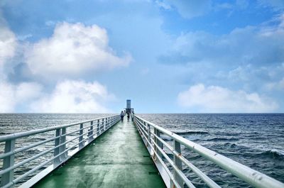 Bridge over calm sea against sky