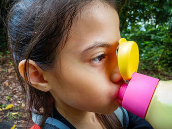 Close-up portrait of cute girl drinking