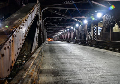 Empty road in illuminated tunnel