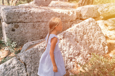 Kid girl traveler of eight years old travel and explore the ancient excavations of ruins