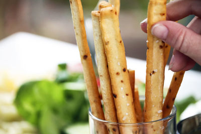 Close-up of hand holding breadstick 