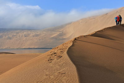 1132 tourists on a dune ridge between sumu jaran-sumu barun jaran lakes. badain jaran desert-china.