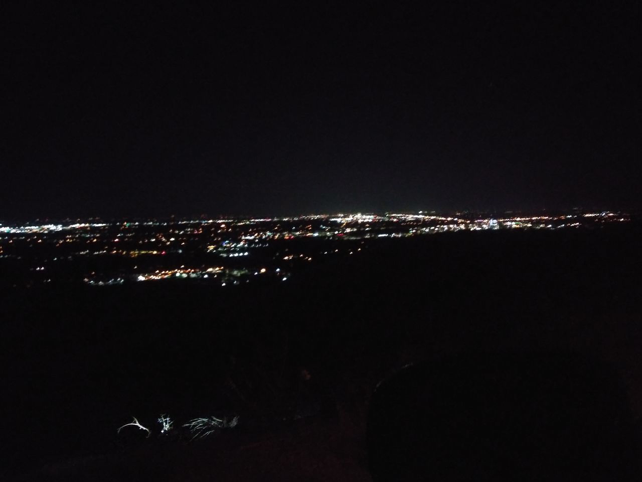 AERIAL VIEW OF ILLUMINATED CITY AGAINST SKY AT NIGHT