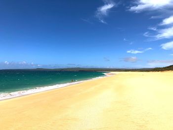 Scenic view of beach against blue sky