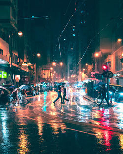 People on wet street at night