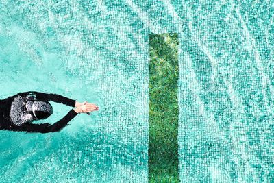 Close-up of human hand in swimming pool