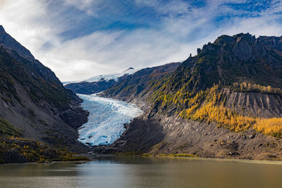 Scenic view of lake by mountains against sky