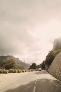 Van moving on road against mountains at sunny day