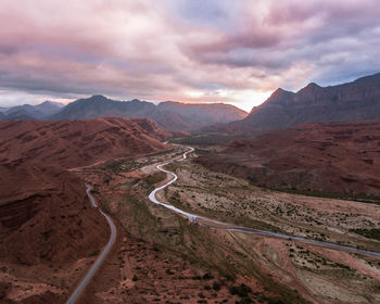 Scenic view of road by mountains against sky