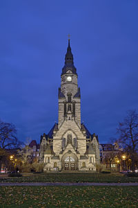 Illuminated building against blue sky at night