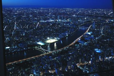 Aerial view of illuminated city against sky at night