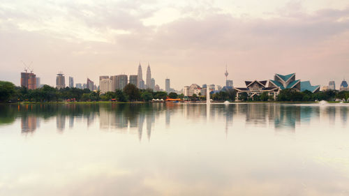 Scenic view of river by city against sky