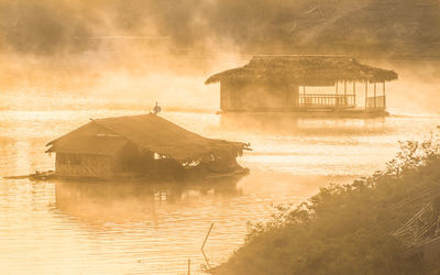 Huts in river at sangkhla buri district during foggy weather