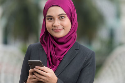 Portrait of a serious young woman using mobile phone