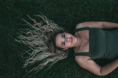 Portrait of young woman lying on grass