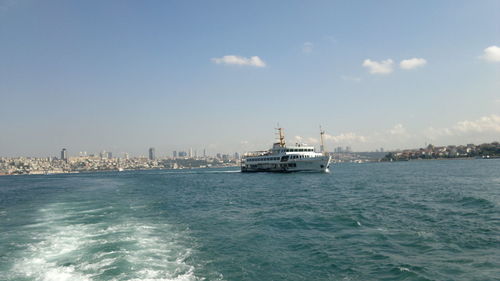 Ship in sea against sky in city
