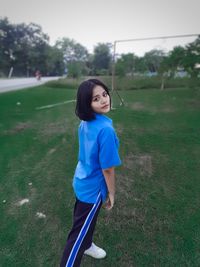 Portrait of woman standing on playground against clear sky
