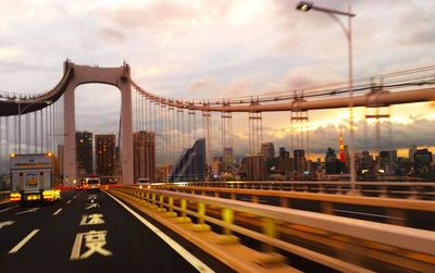 Cars moving on road in city at sunset