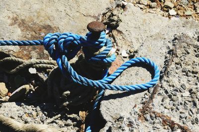 High angle view of rope tied on rock