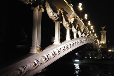 Low angle view of illuminated bridge at night