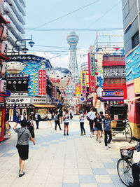 Rear view of people walking on street in city