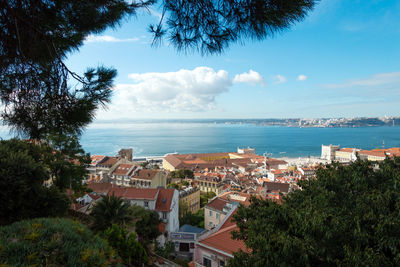 High angle view of townscape by sea against sky