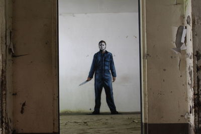 Portrait of young man standing against wall