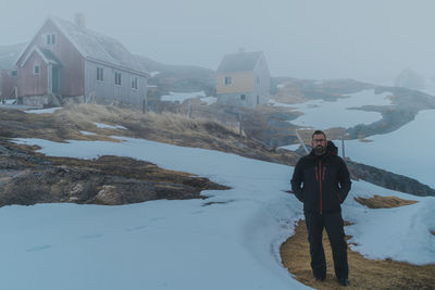 Rear view of man standing on snow covered landscape