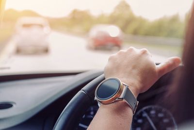 Midsection of woman driving car