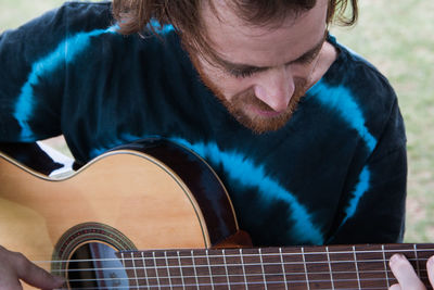 Young guitarist playing guitar outdoors