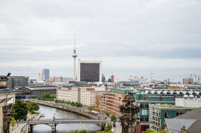 View of cityscape against cloudy sky