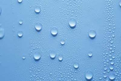 Full frame shot of raindrops on blue window