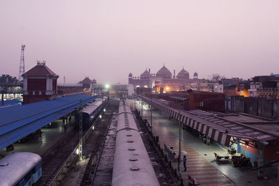 High angle view of illuminated street amidst buildings against sky