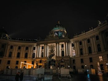 Illuminated building against sky at night