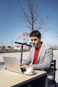 Businessman working on laptop outdoors