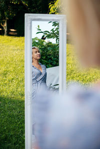 Portrait of young woman sitting on grassy field