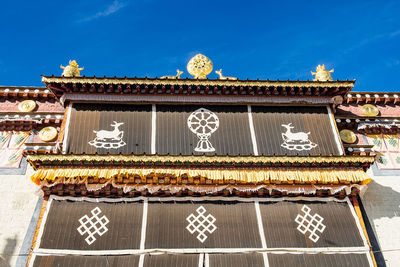 Low angle view of text on building against sky